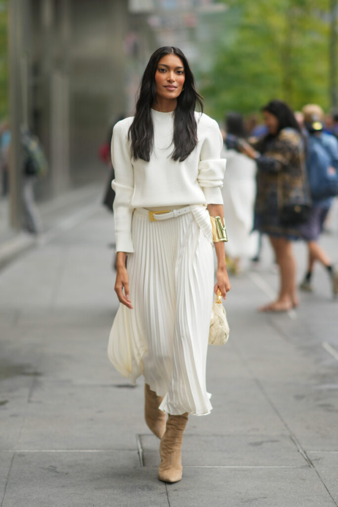 Look casual femenino con suéter de lana, falda midi y botas